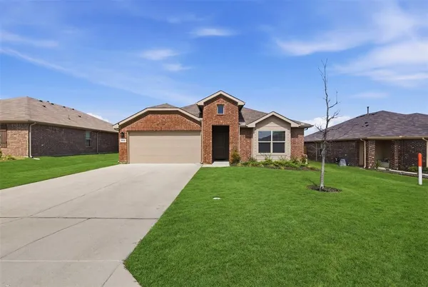 a house with green field in front of it