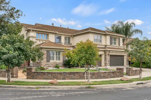 a dining room with furniture potted plants and wooden floor