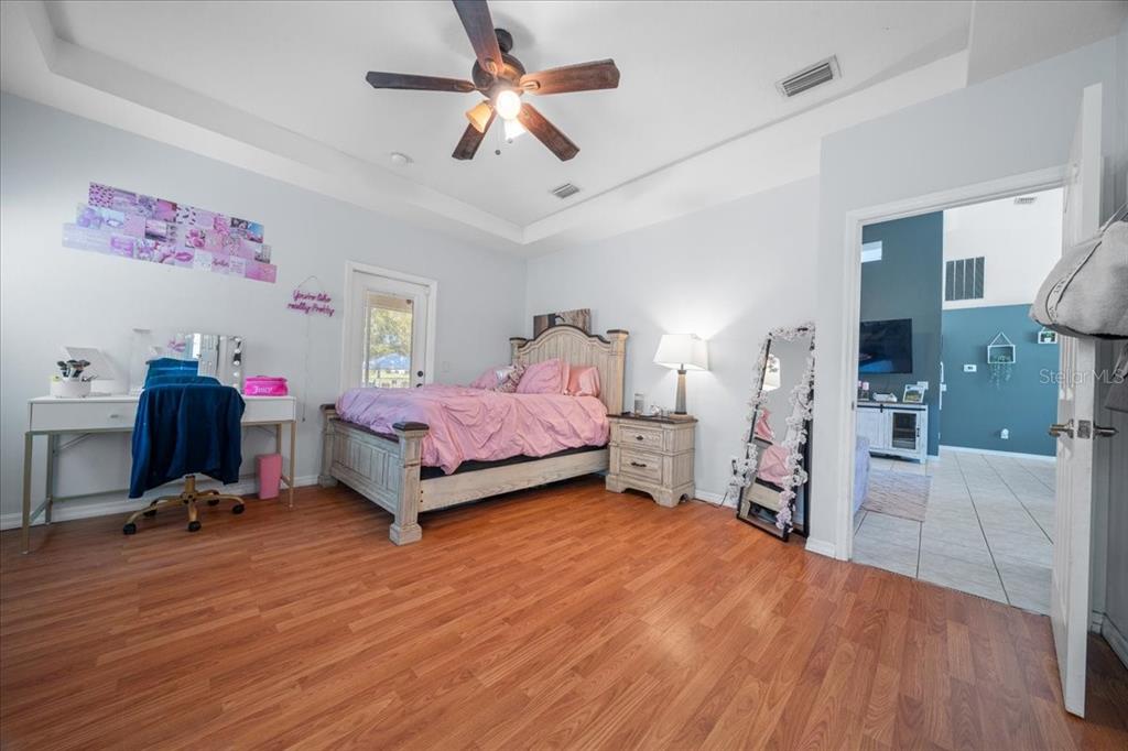 5365 Southwest 111th Lane Road Ocala, FL 34476 - Photo 21 of 42 a spacious bedroom with a bed closet and a flat tv screen