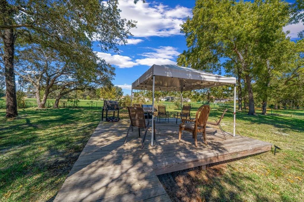 5365 Southwest 111th Lane Road Ocala, FL 34476 - Photo 38 of 42 a view of a table and chairs under an umbrella