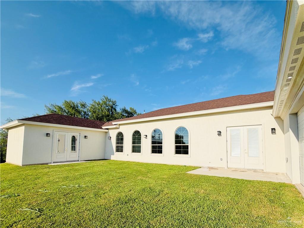 807 Ramirez Street Mission, TX 78573 - Photo 15 of 16 Exterior featuring light-colored stucco, arched windows, and double French doors