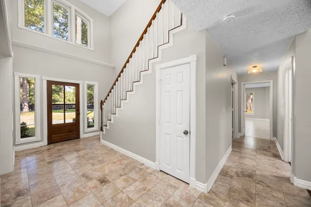 a view of a hallway with a chandelier and stairs