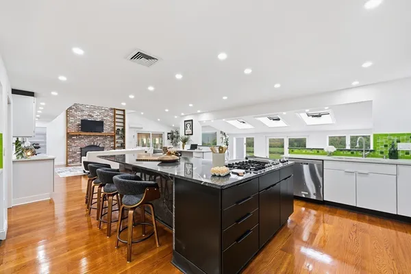 a kitchen with stainless steel appliances kitchen island granite countertop a table and chairs in it