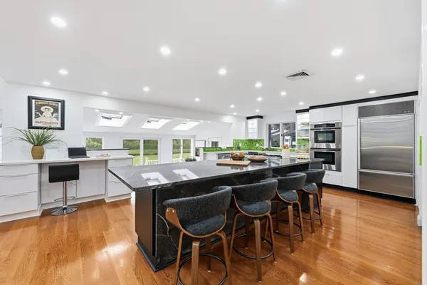 a kitchen with stainless steel appliances granite countertop a stove top oven a sink and a refrigerator