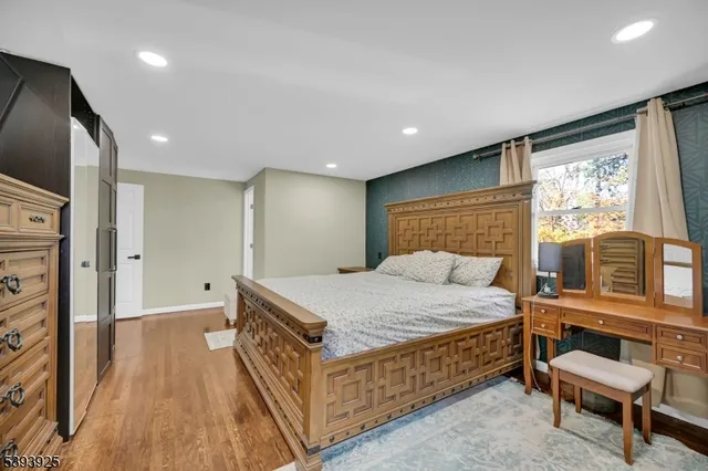 a bedroom with a large bed and a large mirror