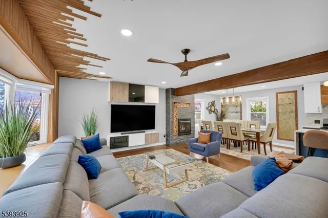a living room with furniture kitchen view and a large window