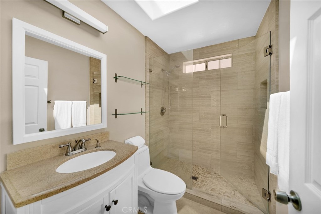 4805 River Avenue, Unit B Newport Beach, CA 92663 - Photo 4 of 9 a bathroom with a granite countertop sink toilet mirror and shower