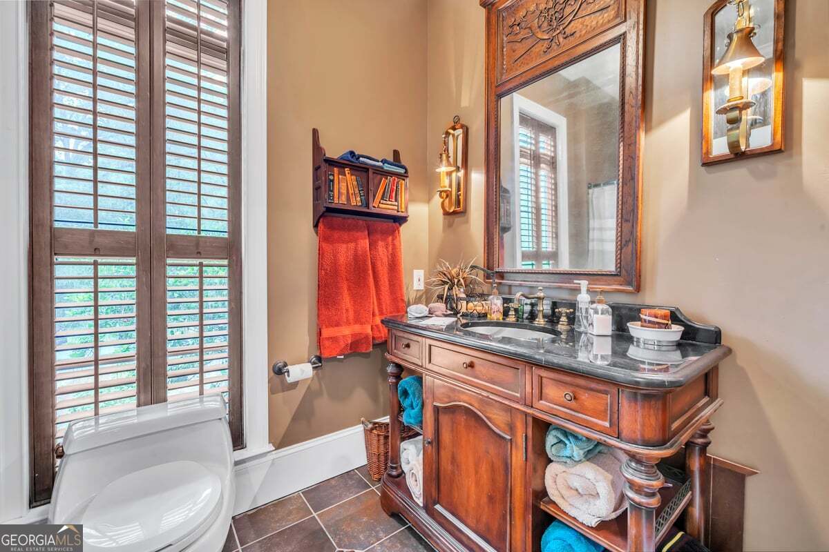 696 Cork Ferry Road Cordele, GA 31015 - Photo 30 of 79 a bathroom with sink a mirror a bathtub and next to a window