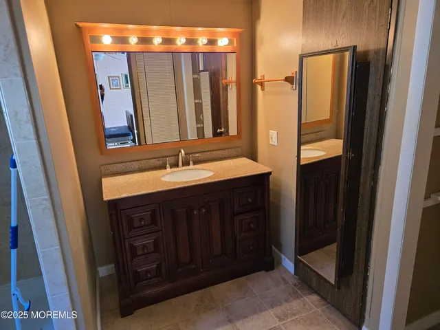 a bathroom with double vanity and a mirror