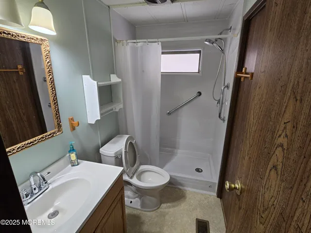 a bathroom with a sink a toilet and shower