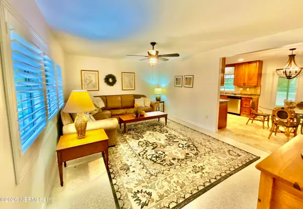 a living room with a couch and dresser next to a window