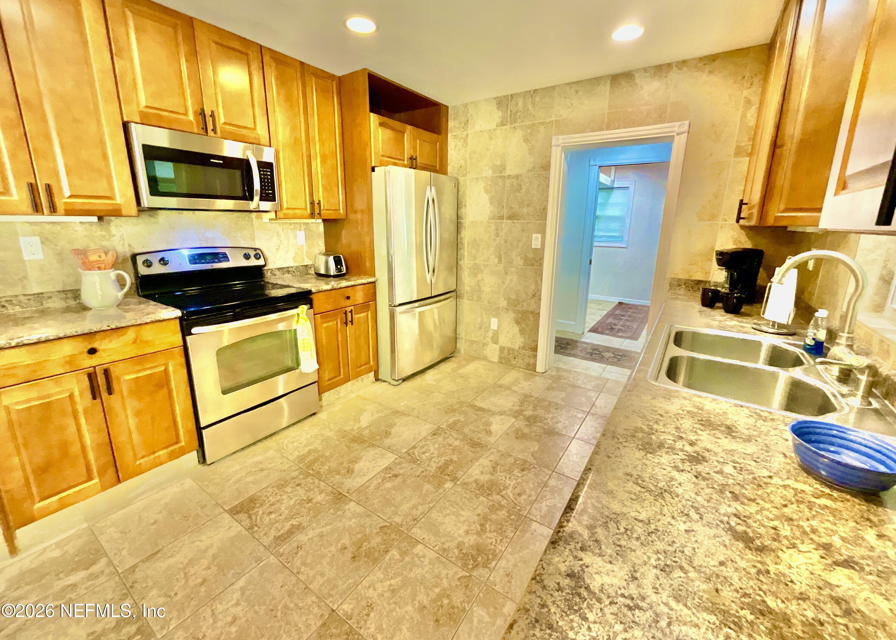17221 Northeast 77th Lane Hawthorne, FL 32640 - Photo 20 of 59 a kitchen with stainless steel appliances granite countertop a stove a sink and a microwave