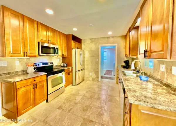 a large white kitchen with a large window