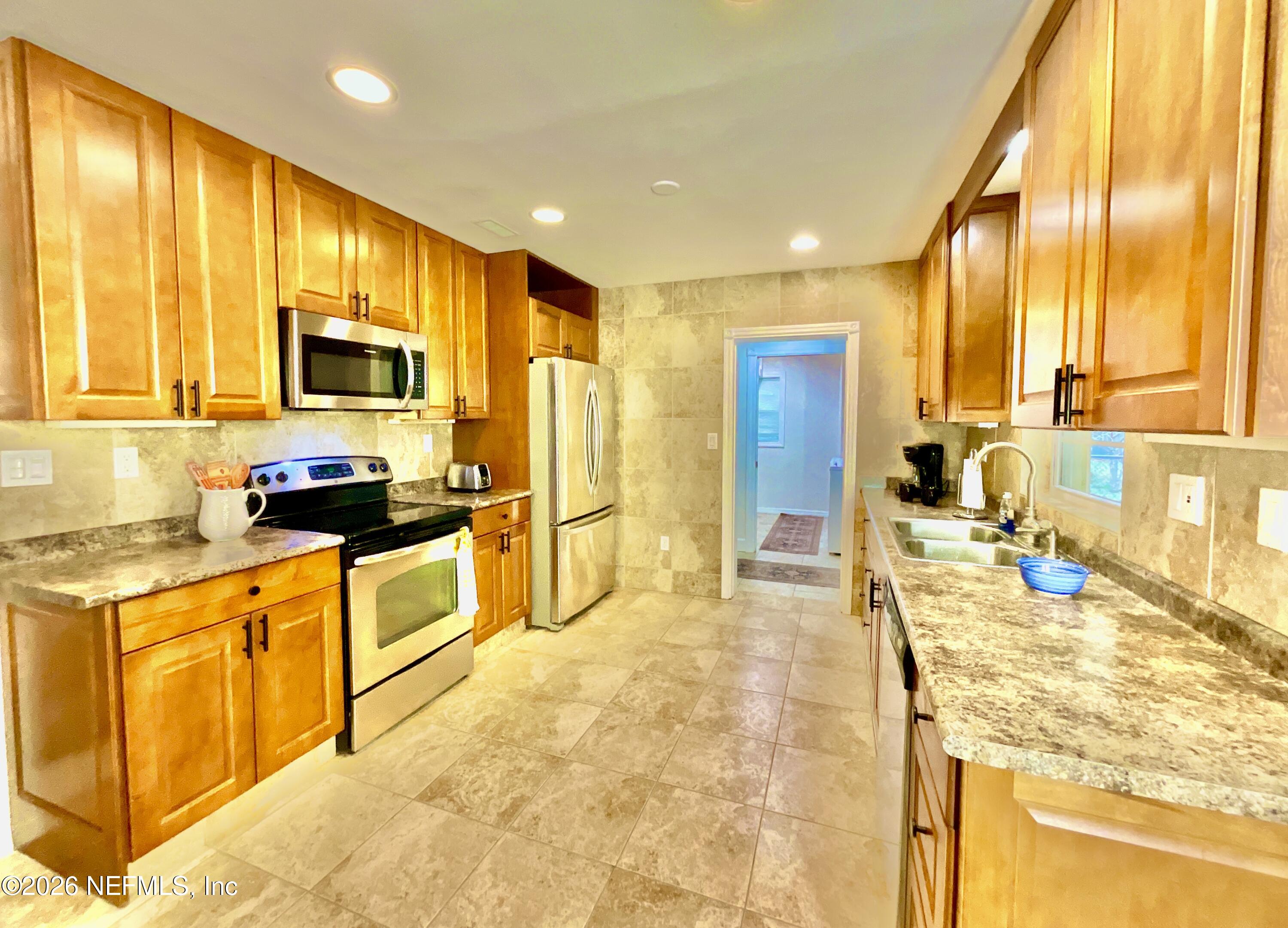 17221 Northeast 77th Lane Hawthorne, FL 32640 - Photo 22 of 59 a kitchen with stainless steel appliances granite countertop sink stove and refrigerator