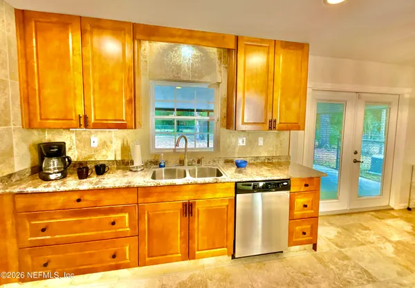 a kitchen with stainless steel appliances granite countertop a refrigerator a stove a dining table and chairs with wooden floor