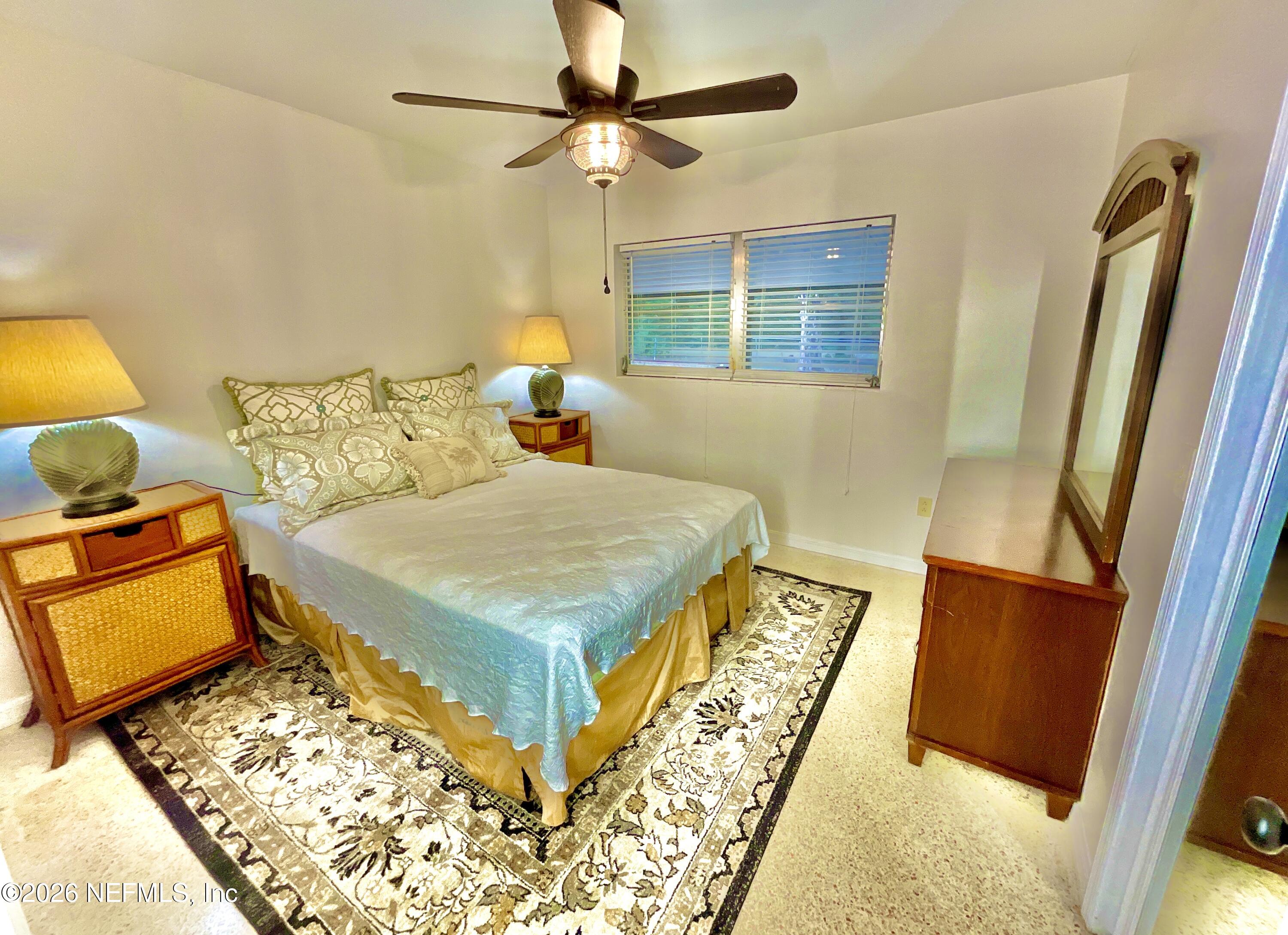 17221 Northeast 77th Lane Hawthorne, FL 32640 - Photo 33 of 59 a bedroom with a bed and a lamp on dresser