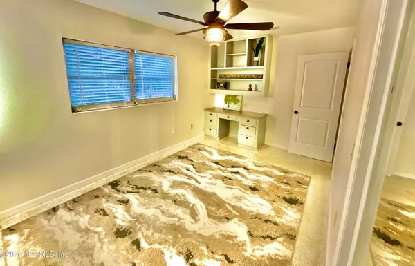a view of a bedroom with wooden floor and ceiling fan