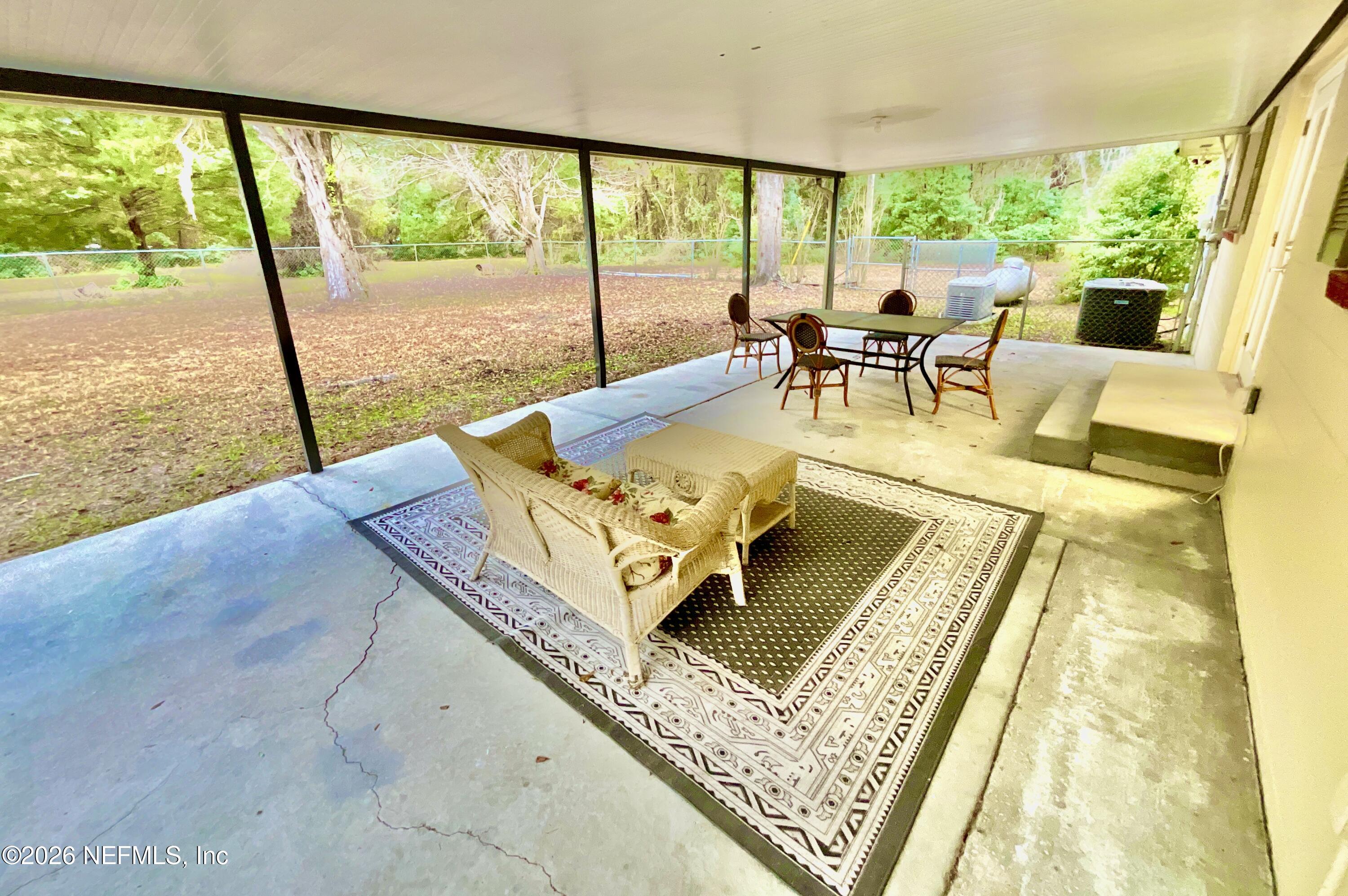17221 Northeast 77th Lane Hawthorne, FL 32640 - Photo 44 of 59 a living room with large trees and a table