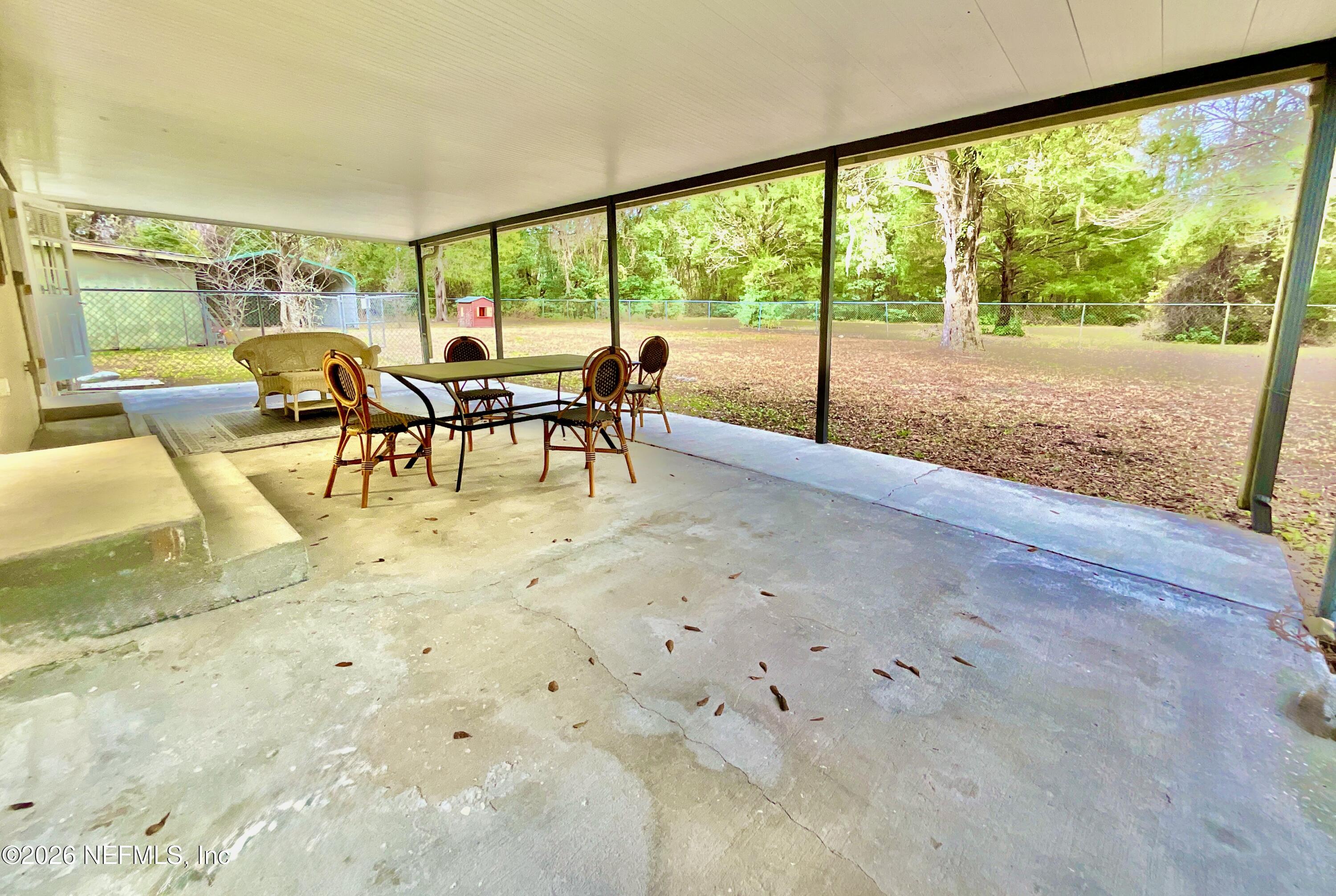 17221 Northeast 77th Lane Hawthorne, FL 32640 - Photo 45 of 59 a view of a dining area with furniture and a floor to ceiling window