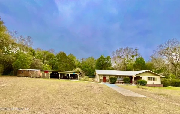 a front view of a house with a yard patio and outdoor seating