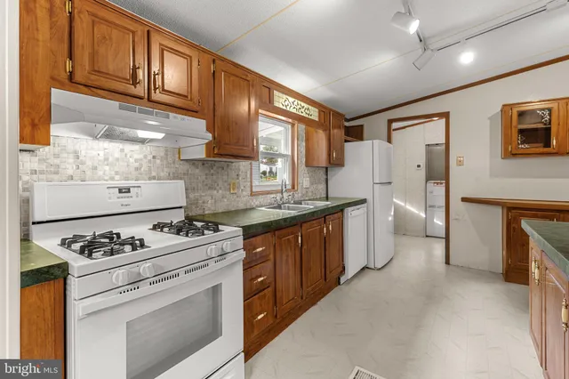a kitchen with granite countertop cabinets stainless steel appliances and a stove