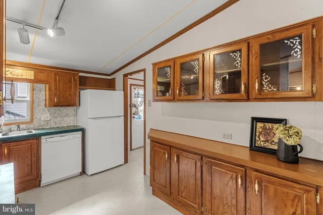 a kitchen with stainless steel appliances granite countertop a refrigerator a sink dishwasher and wooden cabinets with a granite countertops