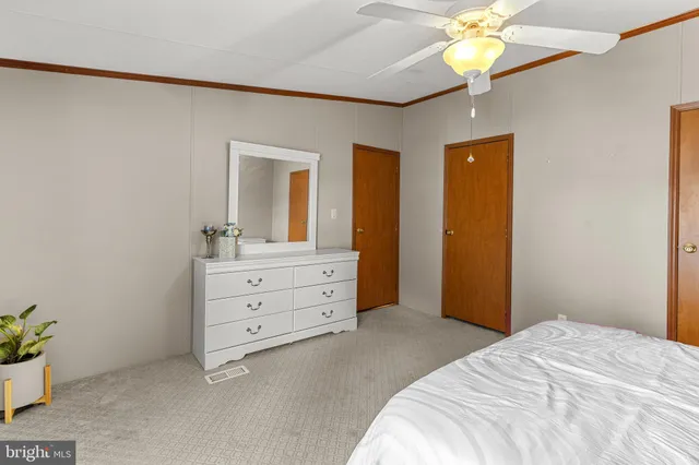 a bedroom with a bed and a chandelier fan