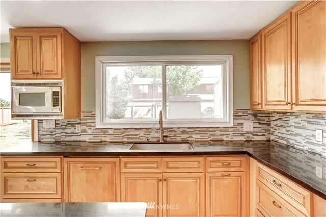 a kitchen with granite countertop a sink and a window