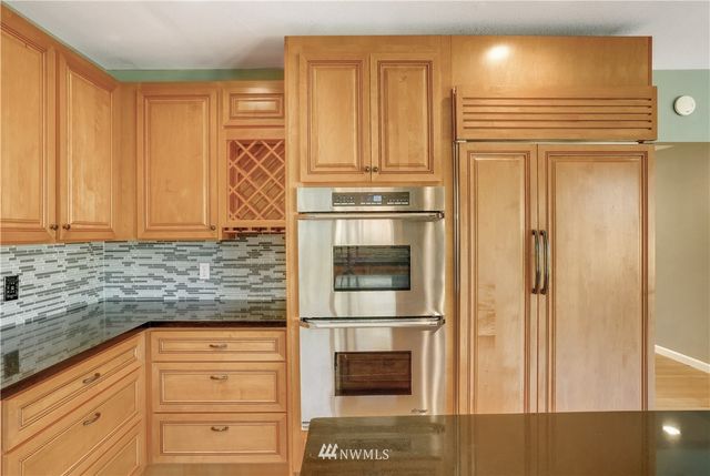 a kitchen with stainless steel appliances granite countertop a refrigerator and cabinets