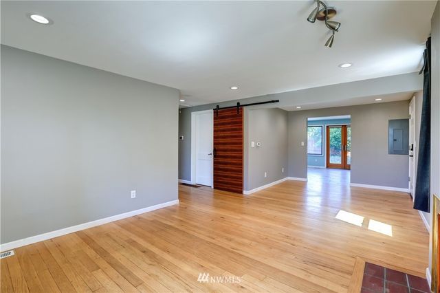 a view of an empty room with wooden floor and entryway