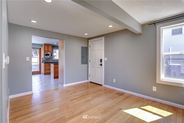 a view of empty room with wooden floor and windows