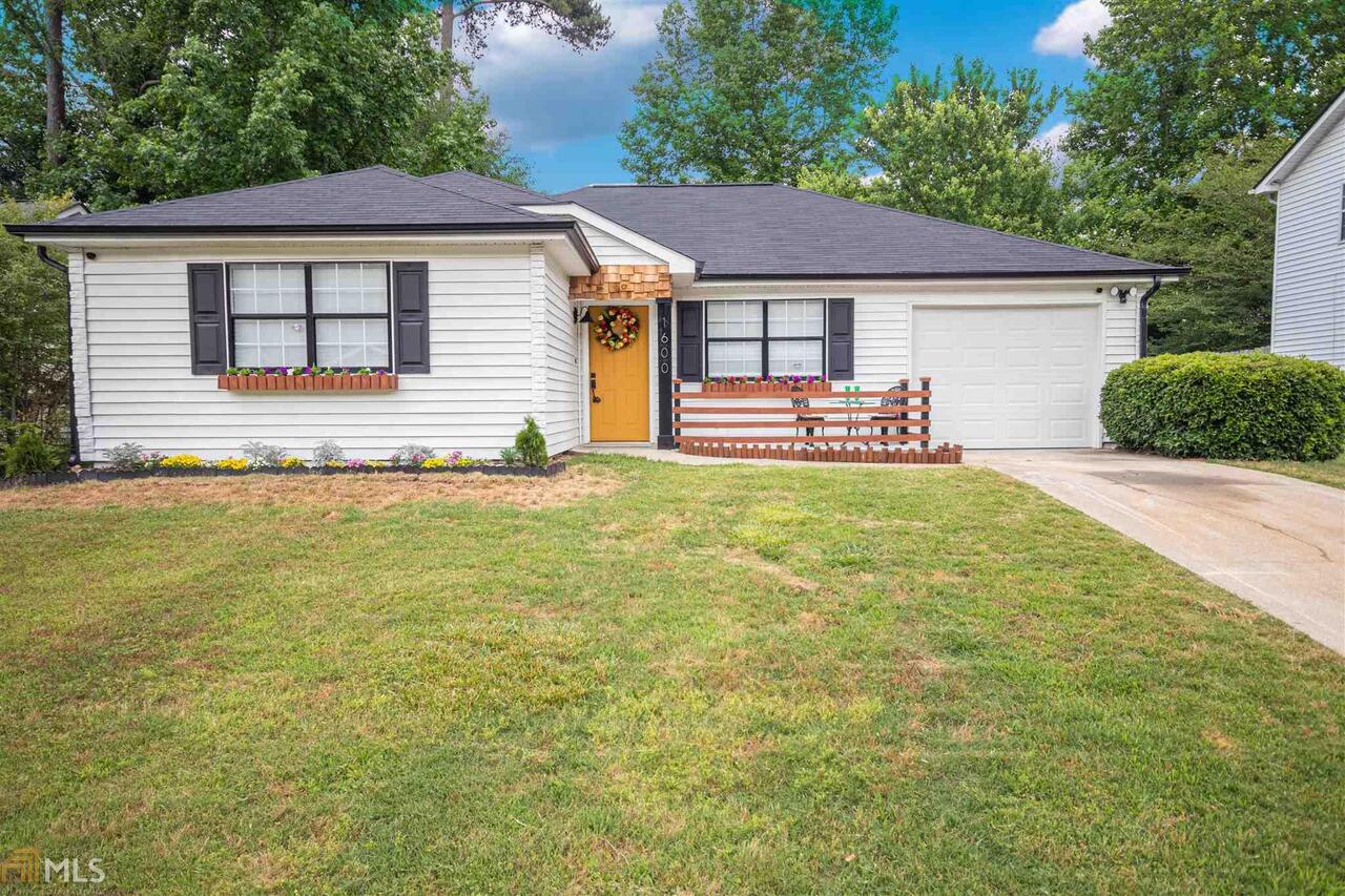 1600 Peachcrest Cove Decatur, GA 30032 - Photo 1 of 1 a front view of a house with a garden and yard