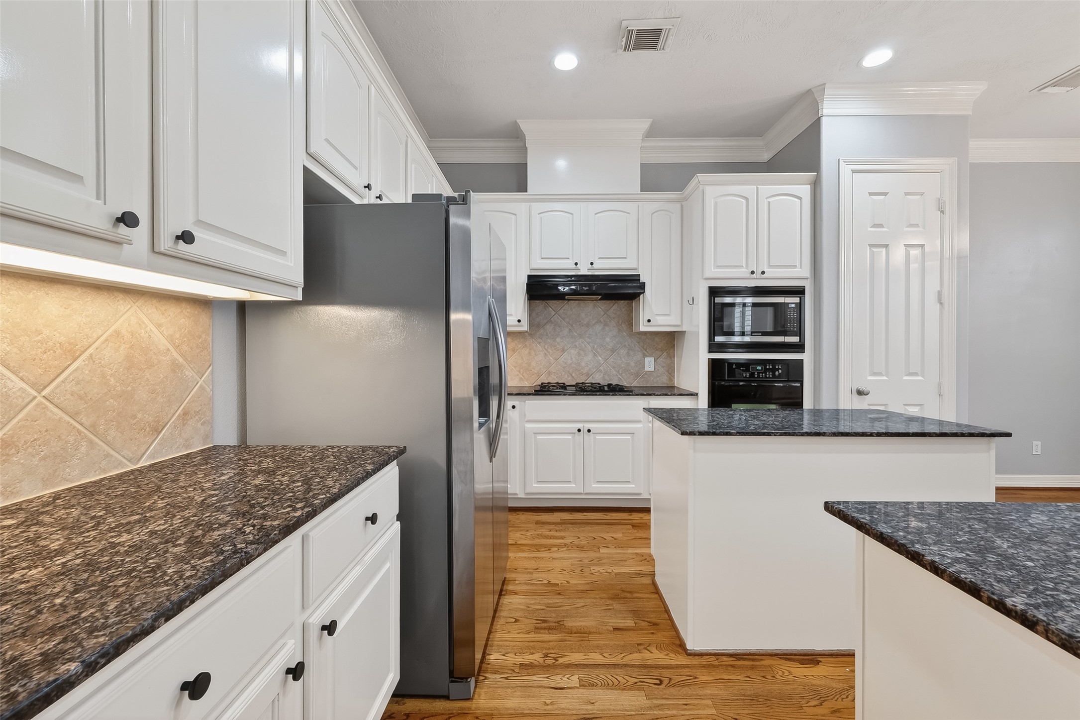 5835 Val Verde Street Houston, TX 77057 - Photo 7 of 21 a kitchen with kitchen island granite countertop a stove a sink and a refrigerator