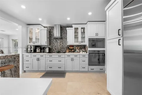 a large white kitchen with cabinets