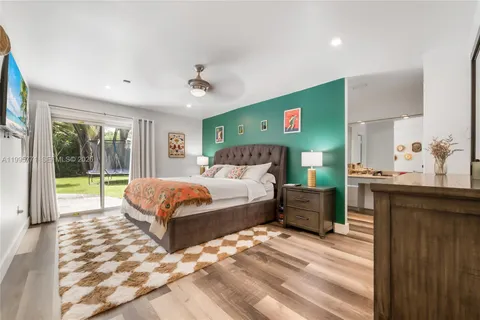 a spacious bedroom with a large bed and a chandelier