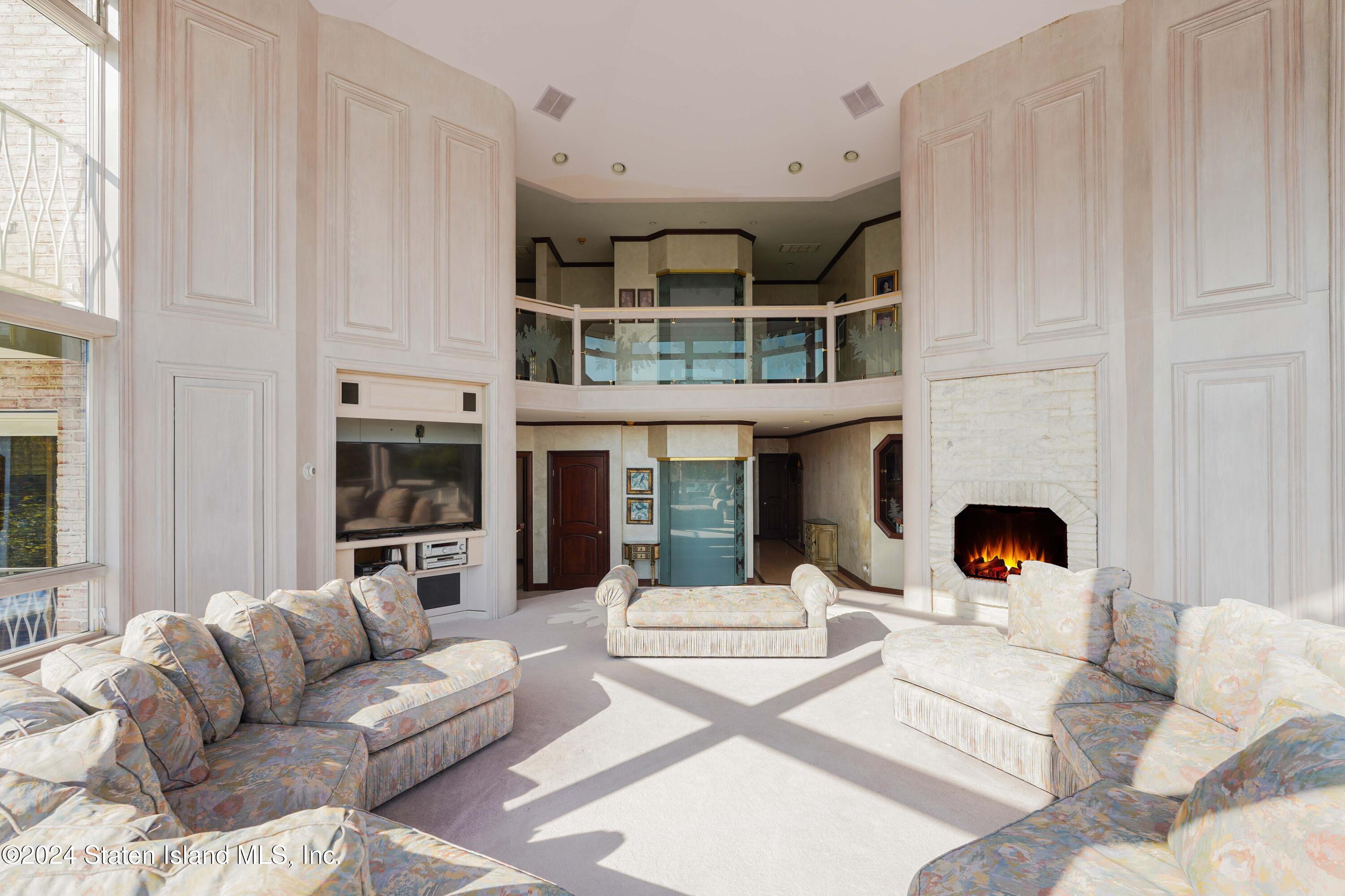12 Romer Road Staten Island, NY 10304 - Photo 25 of 63 a living room with furniture a fireplace and kitchen view