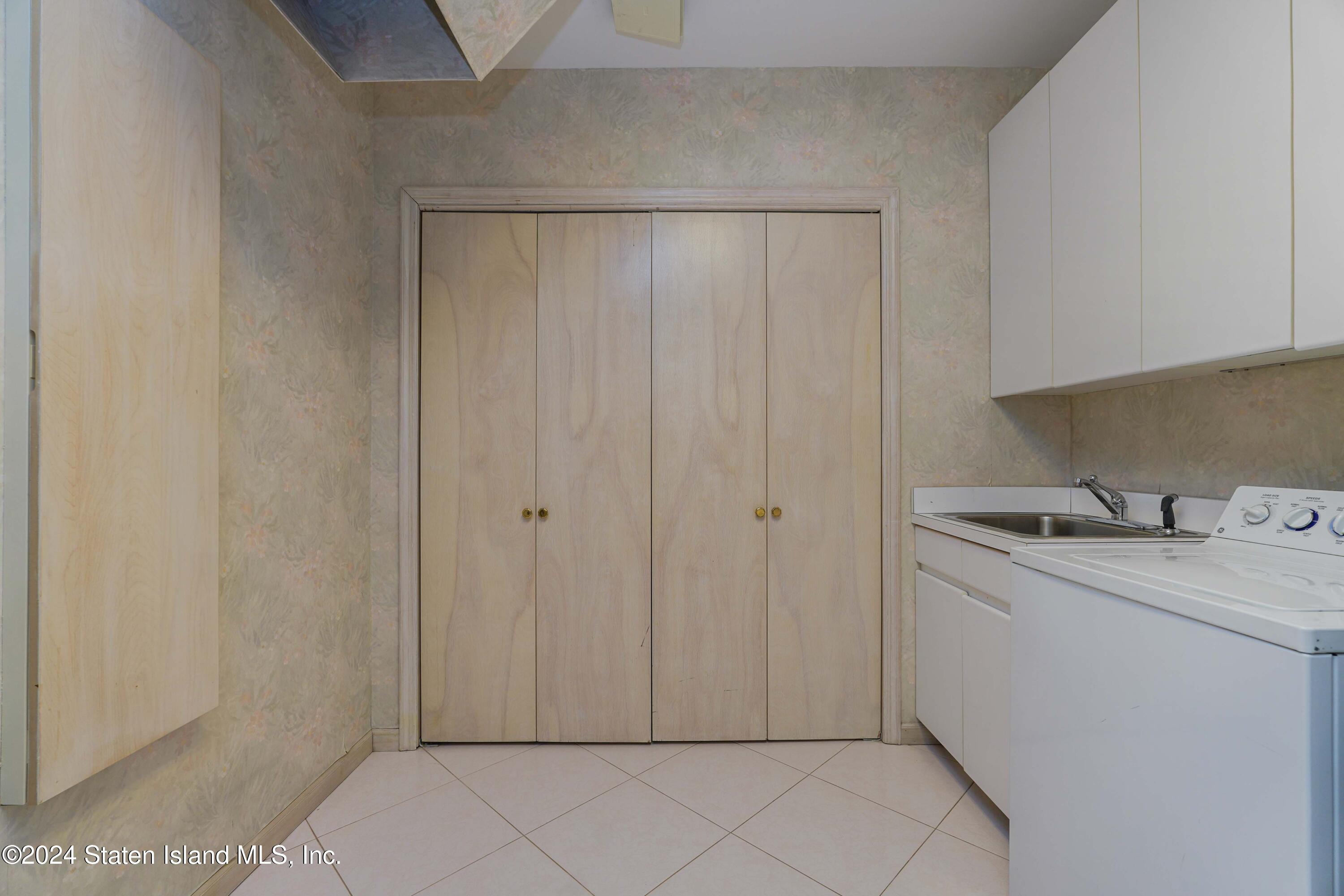 12 Romer Road Staten Island, NY 10304 - Photo 33 of 63 a utility room with cabinets washer and dryer