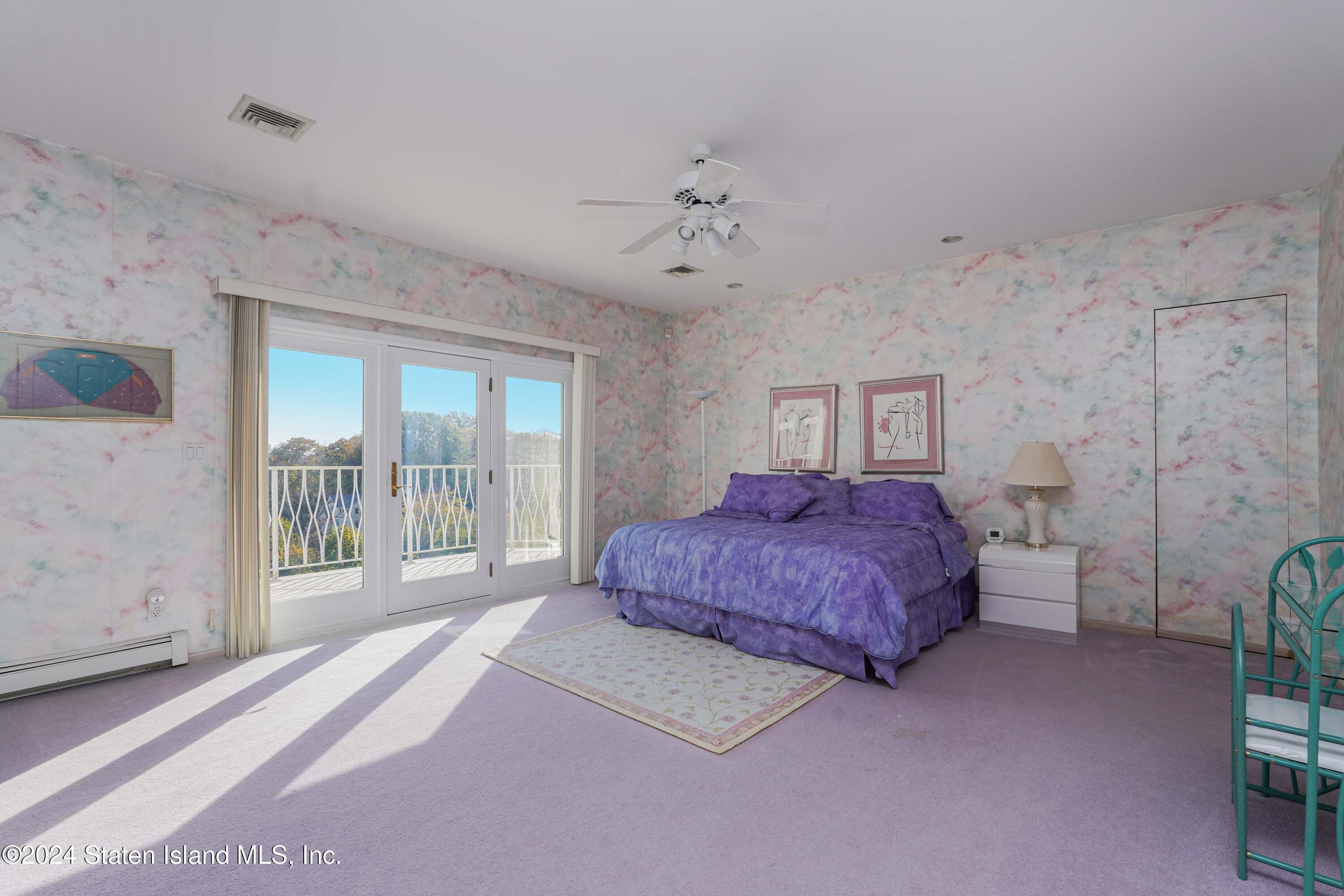 12 Romer Road Staten Island, NY 10304 - Photo 35 of 63 a spacious bedroom with a balcony a bed and a chandelier