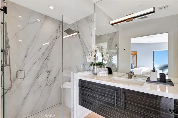 a bathroom with double vanity sink a mirror and a shower