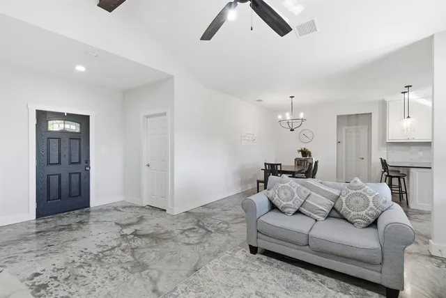 a living room with furniture and a kitchen space