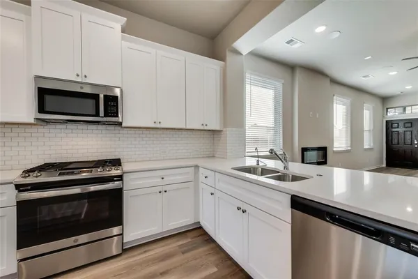 a kitchen with a sink stove and microwave