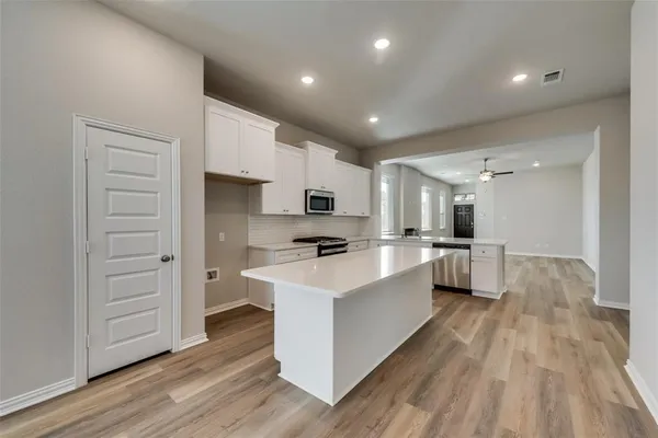 a kitchen with white cabinets and stainless steel appliances