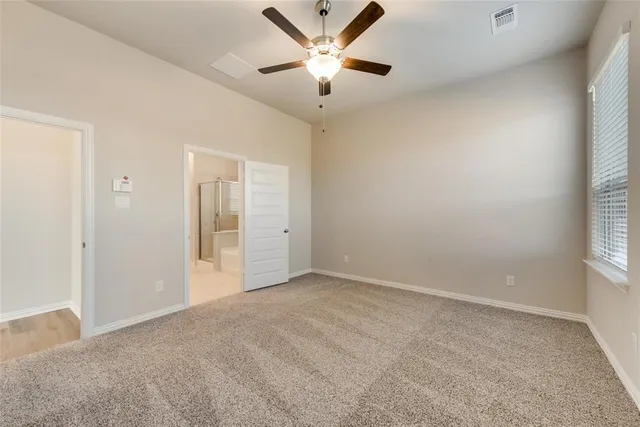 an empty room with a window and a ceiling fan