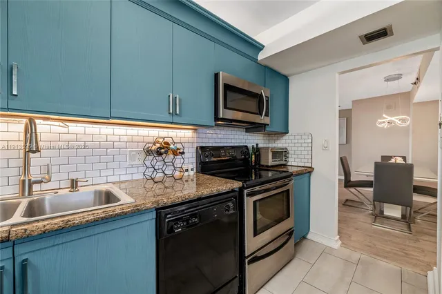 a kitchen with stainless steel appliances granite countertop a sink stove and microwave