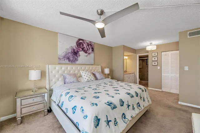 a bedroom with a large bed and a chandelier