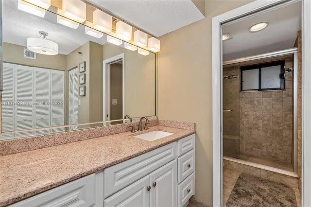 a bathroom with a granite countertop sink mirror and double