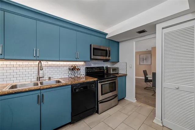 a kitchen with stainless steel appliances granite countertop a stove a sink and a microwave