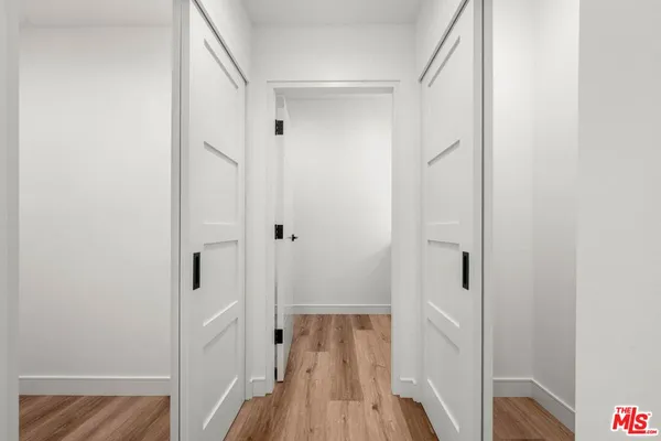 a view of a hallway with wooden floor and closet