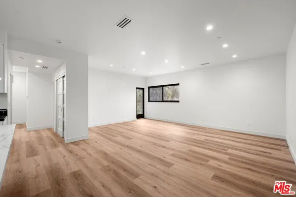 a view of empty room with wooden floor