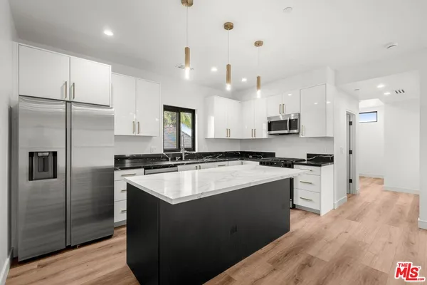 a kitchen with stainless steel appliances granite countertop a sink stove and refrigerator